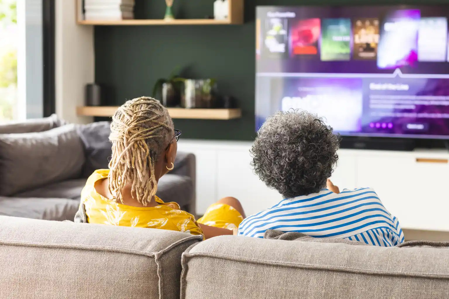 Senior couple relaxing at home while streaming entertainment on a smart TV